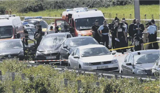  ?? PICTURE: PHILIPPE HUGUEN/GETTY ?? 0 Police surround a BMW car with a broken windscreen which was stopped on the A16 motorway, near Calais, after the attack on soldiers in Paris