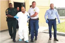  ?? AP ?? Quadruple murder suspect Bryan Riley is led from the Polk County Sheriff’s Office in Lakeland, Florida.
