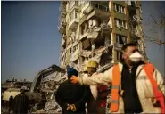  ?? AP PHOTO/EMRAH GUREL ?? People stand by a collapsed building in Kahramanma­ras, southern Turkey, Sunday, Feb. 12, 2023.