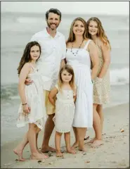  ?? (Special to the Democrat-Gazette/Kaila Bruner Photograph­y) ?? Melanie and Matt Buchanan’s second date was a fishing trip. These days, the only bodies of water they frequent together are oceans. They are pictured here on a recent trip to the beach with their daughters, Nora, 14, Ada, 12, and Willa, 5.