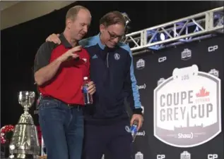  ?? ADRIAN WYLD, THE CANADIAN PRESS ?? Toronto Argonauts head coach Marc Trestman, right, shares a moment with Calgary Stampeders head coach Dave Dickenson as they leave the stage following their news conference Wednesday in Ottawa.