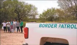  ?? Allison Dinner AFP/Getty Images ?? MIGRANTS ARE processed by Border Patrol after they crossed into the U.S.