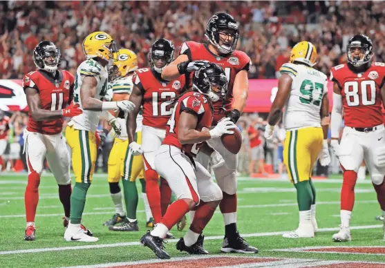  ?? GETTY IMAGES ?? Devonta Freeman celebrates his 1-yard rushing touchdown in the first quarter. Freeman ran for 84 yards and a pair of scores and the Falcons’ offense opened up a 24-7 halftime lead on the short-handed Packers.