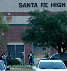  ?? JennIfer reynolDs/The GalVesTon CounTy DaIly news VIa aP ?? In this Aug. 20 file photo, Santa Fe High School students arrive for the first day of the new school year in Santa Fe, Texas. A growing number of students are leaving the Houston-area school district where 10 people were killed in a mass shooting in May. Enrollment at the Santa Fe public school district has dropped by more than 4 percent this year. Half of the loss comes from Santa Fe High School, where authoritie­s say a 17-year-old student fatally shot 10 people.