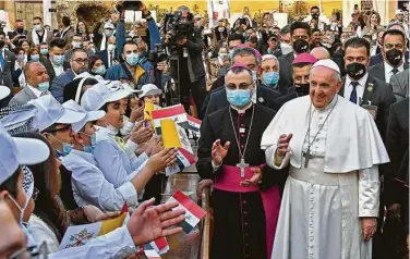  ?? Vincenzo Pinto / AFP via Getty Images ?? Children greet Pope Francis as he arrives Saturday at Baghdad’s Saint Joseph Cathedral on the second day of the first papal visit to Iraq. The pope made a plea for peace at an interrelig­ious service in southern Iraq.