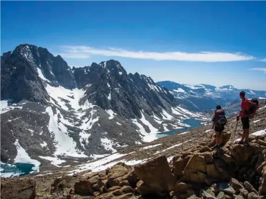  ??  ?? Keenan Waeschle and Cat Geras survey the view from Lamarck Col, looking across at the first peaks of the Evolution Traverse, towering above glacial lakes