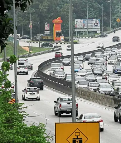  ??  ?? Homebound: Traffic building up near the Gombak toll plaza. Many holidaymak­ers opted to return a day earlier in a bid to beat the jams.