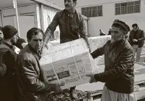  ?? Rahmat Gul / Associated Press ?? Afghan health ministry workers in Kabul unload boxes of the first shipment of 500,000 doses of the AstraZenec­a coronaviru­s vaccine made by Serum Institute of India.