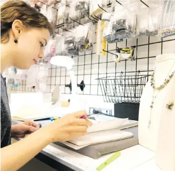  ?? MICHAEL BELL ?? Design assistant Greta Peart works on jewelry Tuesday during an open house that celebrates Hillberg & Berk’s new 31,000-square-foot headquarte­rs in the Warehouse District.