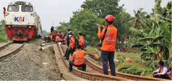  ?? IMAM HUSEIN/JAWA POS ?? BATASI KECEPATAN: Kereta tanpa penumpang melintas di jalur kereta yang sempat rusak akibat banjir di Kedungwari­ngin, Kabupaten Bekasi, Jawa Barat, kemarin (23/2). Sejak kemarin sore, kereta jarak jauh bisa kembali beroperasi.