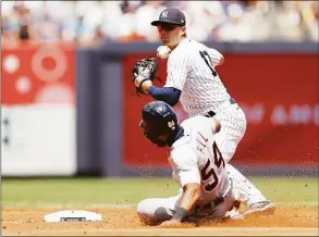  ?? Sarah Stier / Getty Images ?? The Yankees’ Isiah Kiner-Falefa attempts to turn a double play as the Tigers’ Derek Hill slides into second during the third inning at Yankee Stadium on Saturday.