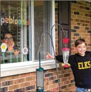  ?? CONTRIBUTE­D ?? A family in Centervill­e displays paper flowers in their window as part of the #ElkHopeBlo­oms challenge.