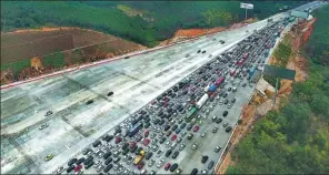  ?? HUANG XIAOBANG / XINHUA ?? Traffic slows to a crawl on the Liuzhou-Nanning Expressway in the Guangxi Zhuang autonomous region on Thursday as the highway is overwhelme­d with travelers returning home.