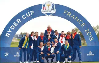  ?? REUTERS ?? TEAM EUROPE captain Thomas Bjorn poses with the trophy and team mates as they celebrate after winning the Ryder Cup.