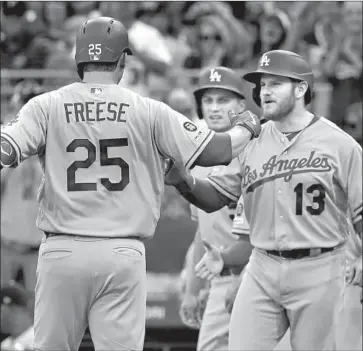  ?? Gene J. Puskar Associated Press ?? DAVID FREESE IS GREETED at home plate by Max Muncy (13) and Corey Seager after his grand slam.