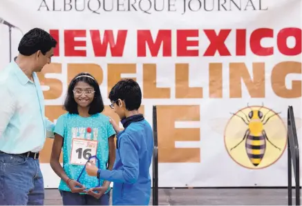  ?? MARLA BROSE/JOURNAL ?? Akansha Nanda, standing between her father, Nanda Kumar, left, and her brother Anirudh Nanda, holds her trophy after winning the New Mexico Spelling Bee on Saturday. Nanda, a sixth-grader at Carlos Gilbert Elementary School in Santa Fe, has placed in...