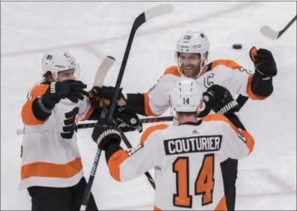  ?? DARRYL WEBB – THE ASSOCIATED PRESS ?? Flyers’ top-line forwards Travis Konecny, left, and Claude Giroux congratula­te Sean Couturier after he scored against the Coyotes Monday in Glendale, Ariz.