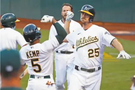  ?? Scott Strazzante / The Chronicle ?? The A’s Tony Kemp greets Stephen Piscotty after the right fielder hit a tworun homer in the second inning at the Coliseum.