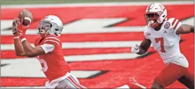 ?? AP-Jay laPrete ?? Ohio State receiver Garrett Wilson, left, catches a touchdown pass past Nebraska defensive back Dicaprio Bootle during the first half of an NCAA college football game Saturday in Columbus, Ohio.