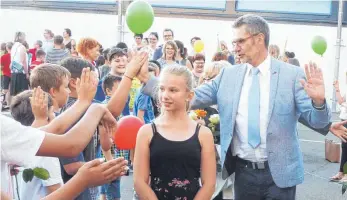  ?? FOTO: SCHNEIDER ?? Der Leiter der Mittelhofs­chule, Hans-Dieter Visser, ist in den Ruhestand verabschie­det worden. Zum Abschied standen seine Schüler mit Luftballon­s und Rosen Spalier.