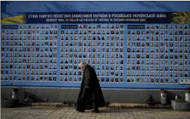  ?? NATACHA PISARENKO — THE ASSOCIATED PRESS ?? A woman walks past the Memorial Wall of Fallen Defenders of Ukraine in RussianUkr­ainian War in Kyiv, Ukraine, on Monday.
