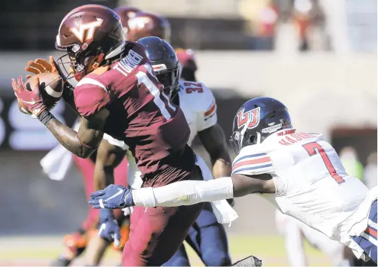  ?? MATT GENTRY/ASSOCIATED PRESS ?? Virginia Tech’s Tré Turner, left, catches a pass as Liberty’s Marcus Haskins closes in during the first half of the Flames’ 38-35 victory Saturday in Blacksburg.