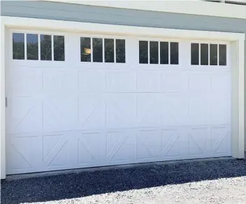  ?? Photos courtesy Maui Garage Doors, Inc. ?? Clockwise from top left photo: Commercial rolling slat doors, such as this one, are extremely durable and secure. • Give your home that natural look with this custom knotwood overlay garage-door package. • This steel Classica Collection door is fitted with windows to allow for natural light.