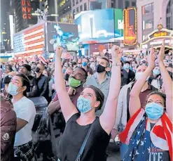  ?? REUTERS/ANDREW KELLY ?? Una multitud de votantes de Biden festejan en Times Square cuando se anunciaron los números ganadores de Pensilvani­a.