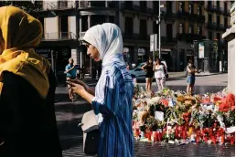  ?? Reuters; Getty ?? Top, a French soldier stands guard under the Eiffel Tower in Paris. Above, a memorial tribute of flowers and candles to the victims of the terrorist attack on the popular street of La Rambla in Barcelona