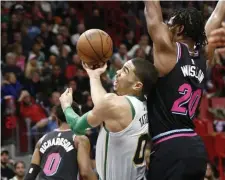  ?? ASSOCIATED PRESS ?? CAUGHT IN A TRAP: Jayson Tatum tries to shoot while being closely guarded by the Heat’s Justise Winslow during the Celtics’ 115-99 loss last night in Miami.