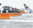  ??  ?? Traktoren mit Schneescha­ufeln befreien das Vorfeld am Flughafen München von Schnee.