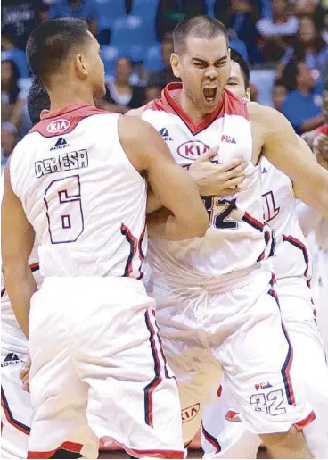  ??  ?? Hyram Bagatsing (32) reacts as he is mobbed by his teammates after drilling in the winning trey that lifted the Kia Carnival past the NLEX Road Warriors.