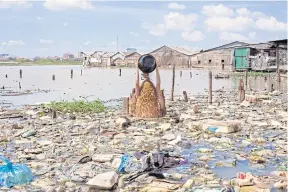  ??  ?? Artist Khvay Samnang pours sand over his head to protest against the spread of landfill.