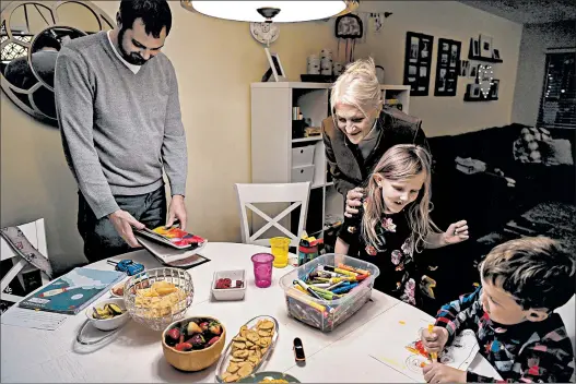  ?? CAROLYN VAN HOUTEN/WASHINGTON POST PHOTOS ?? Matthew White helps his kids with homework in Carmel, Ind. At center is his mom, Liz, who was inseminate­d with her fertility doctor's sperm to conceive her son 35-plus years ago. As accusation­s against Dr. Donald Cline increased, he faced criminal charges and lost his medical license.