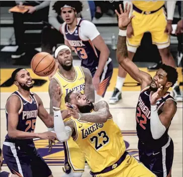  ?? Robert Gauthier Los Angeles Times ?? LeBRON JAMES LEANS and gets a basket and a foul on Phoenix center Deandre Ayton, right, late in the first half at Staples Center. James wound up with 38 points, making 16 of 24 shots in the loss.