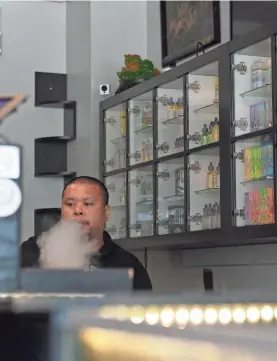  ?? JACK GRUBER/USA TODAY ?? Brandon Nguyen, co-founder of Vapor Solutions DMV, vapes at the store in Falls Church, Va. The FDA is researchin­g flavor in vaping.