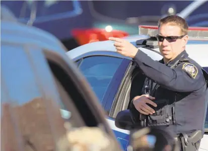  ?? KARL MERTON FERRON/BALTIMORE SUN ?? A police officer points at a staging area Thursday on Joppa Road during a manhunt for former Baltimore County cop Robert Vicosa, who allegedly kidnapped his two daughters from his estranged wife in southern Pennsylvan­ia and went on the run.