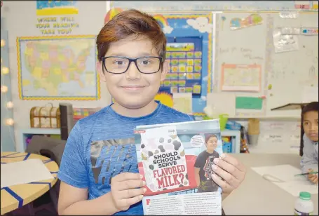 ?? RACHEL DICKERSON/MCDONALD COUNTY PRESS ?? Esteban Perez, a fourth-grader at Anderson Elementary School, holds up a copy of Scholastic News in which he was mentioned and pictured. He made national news after circulatin­g a petition at his school to get strawberry milk served again, leading to the return of the drink to the entire district.