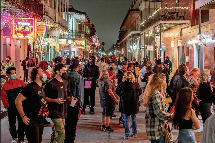  ?? EMILY KASK / NEW YORK TIMES FILE (2021) ?? People party on Bourbon Street in New Orleans on Feb. 11, 2021, the last night before it was shut down for Mardi Gras.