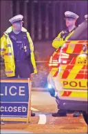  ??  ?? GRIM AFTERMATH: Police in Reading, UK, stand watch after three people were stabbed to death in a seemingly random attack.