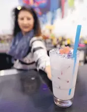  ??  ?? Manager Sandra Vacca serves a Purple Passion Italian soda at Float, the new cafe/bar at Meow Wolf.