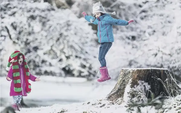  ??  ?? Youngsters Robyn, four, and Anan, six, enjoy the wintry conditions at Rouken Glen Park in East Renfrewshi­re. Warnings have been issued for more snow and ice today and tomorrow after the cold snap disrupted travel on both sides of the Border.