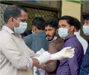  ?? AP ?? Indians standing in a queue outside a hospital wear masks as a precaution­ary measure against the Nipah virus in Kozhikode, Kerala, on Monday. —