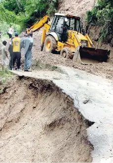  ?? FILE ?? A tractor contracted by the National Works Agency clears a section of Jacks Hill Road in St Andrew after it was blocked by a landslide caused by Tropical Storm Gustav in 2008.