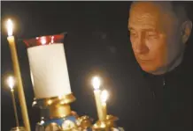  ?? Sputnik, Kremlin pool photo via AP ?? Russian President Vladimir Putin lights a candle to commemorat­e the victims of an attack on the Crocus City Hall concert venue, on the day of national mourning, in Russia, on Sunday.