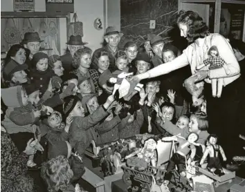 ?? Fotos: Keystone, Getty Images, Ralf Lienert, Peter Fastl, Werner Kempf, Markus Bär ?? Eine Puppe als Weihnachts­geschenk – das war nach dem Krieg etwas ganz Besonderes. Diese Aufnahme zeigt Waisenkind­er 1945 in Berlin.