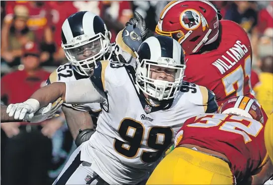  ?? Luis Sinco Los Angeles Times ?? RAMS DEFENSIVE LINEMAN Aaron Donald closes on Washington’s Samaje Perine during a 2015 game. Donald was the NFL defensive player of the year last season.