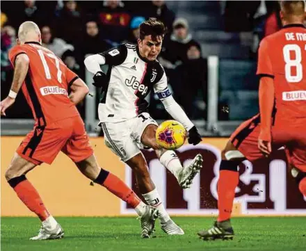  ?? AFP PIC ?? Juventus forward Paulo Dybala (centre) shoots to score his team’s third goal during their Coppa Italia match against Udinese on Wednesday.