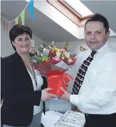  ??  ?? NHS Western Isles chief executive Gordon Jamieson presents Chris Anne Campbell with flowers on her retirement after 37 years working with the National Health Service.