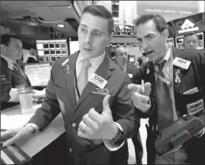  ?? AP/RICHARD DREW ?? Specialist Joseph Mastrolia (left) and trader Gregory Rowe work Wednesday on the floor of the
New York Stock Exchange.